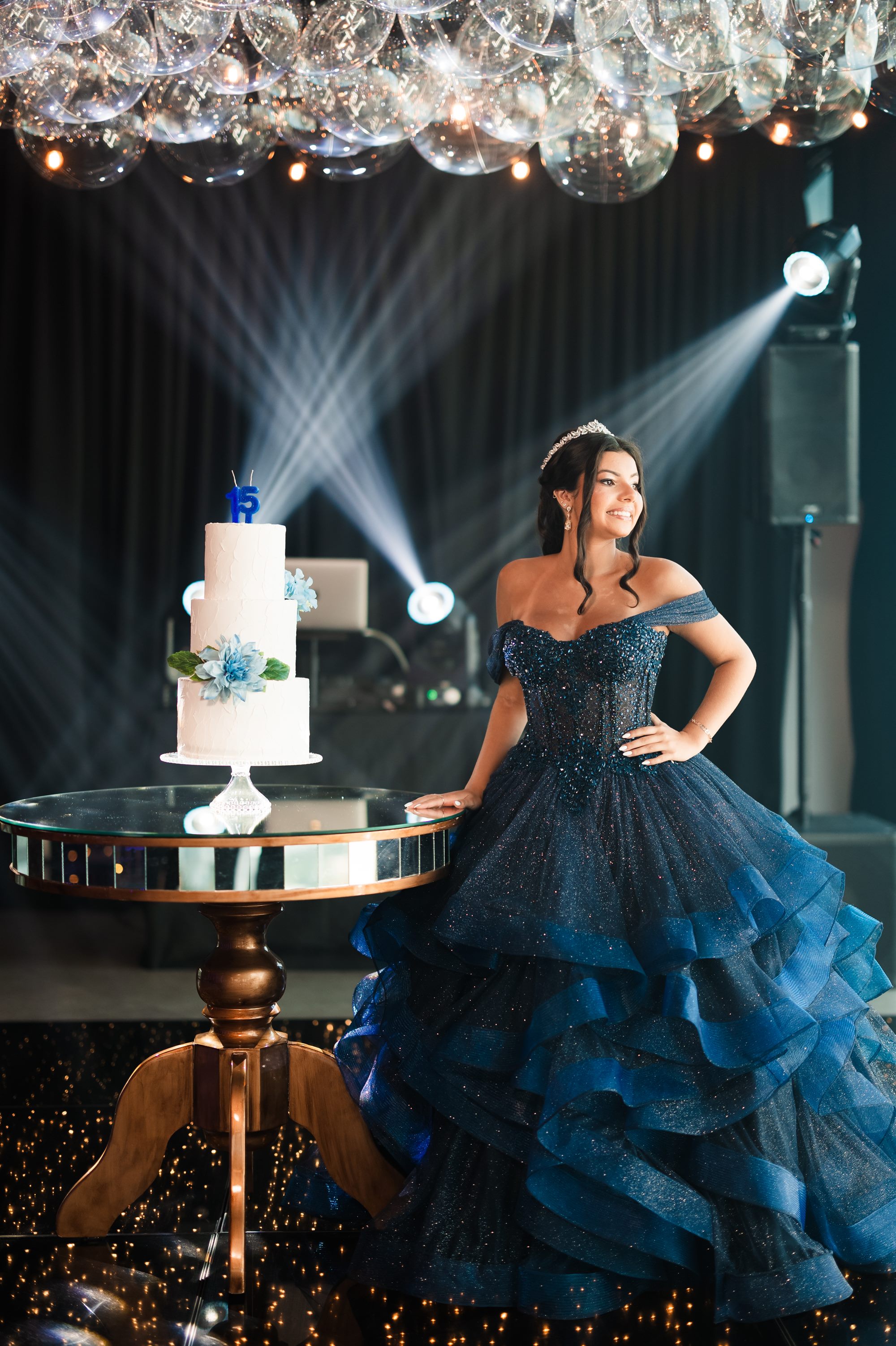 Debutante de tiara ao lado do bolo de 15 anos, em evento real Indaiá
